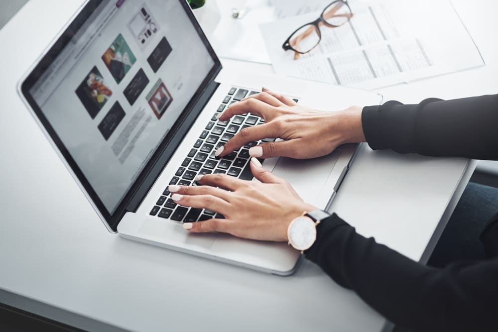 main d'une personne consultant les archives d'une émission sur son ordinateur portable