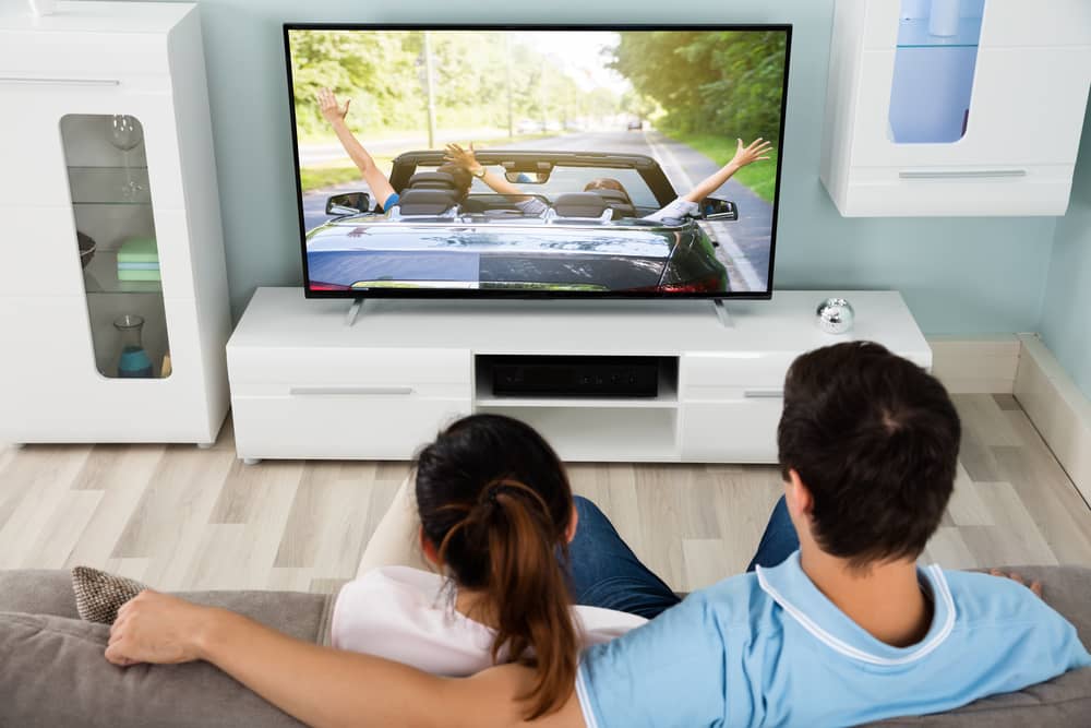 couple regardant la chaîne Auto Plus TV sur leur télévision