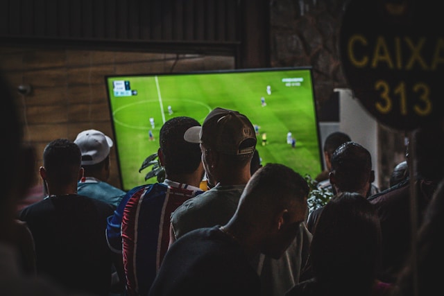groupe d'hommes regardant un match de football via la plateforme DAZN