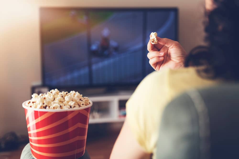 vue de dos d'une personne regardant la chaîne Drive-in Movie Channel en mangeant des popcorns