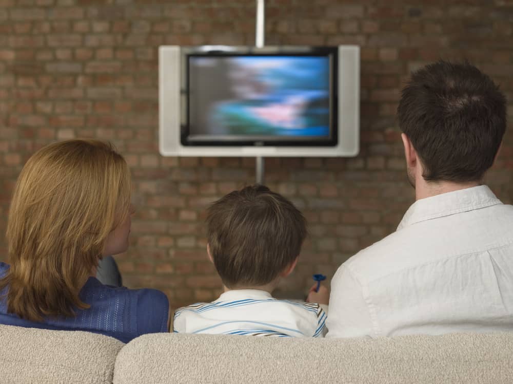 un couple et son fils regardent la chaîne LCP AN à la télévision