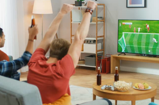 Amis regardant un match de football à la télévision