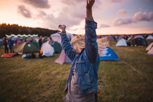jeune femme blonde levant les bras devant le camping des Déferlantes