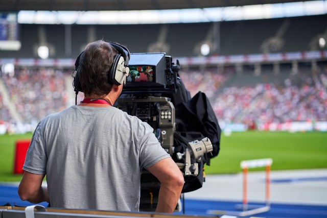 caméraman filmant une compétition d'athlétisme commentée par Nelson Monfort