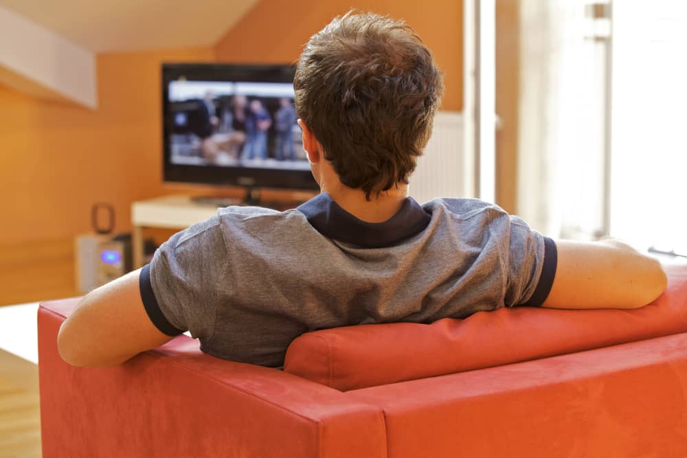 homme regardant une émission présentée par Pascal Praud à la télévision