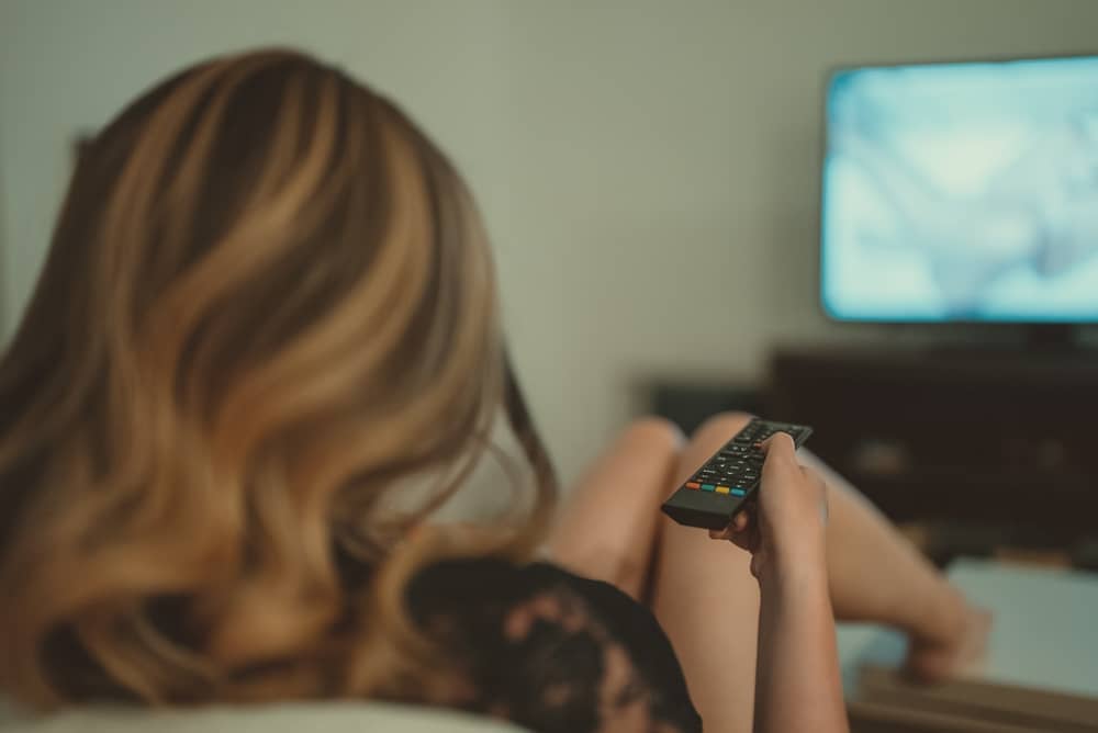 femme tenant une télécommande en regardant la chaîne Syfy France