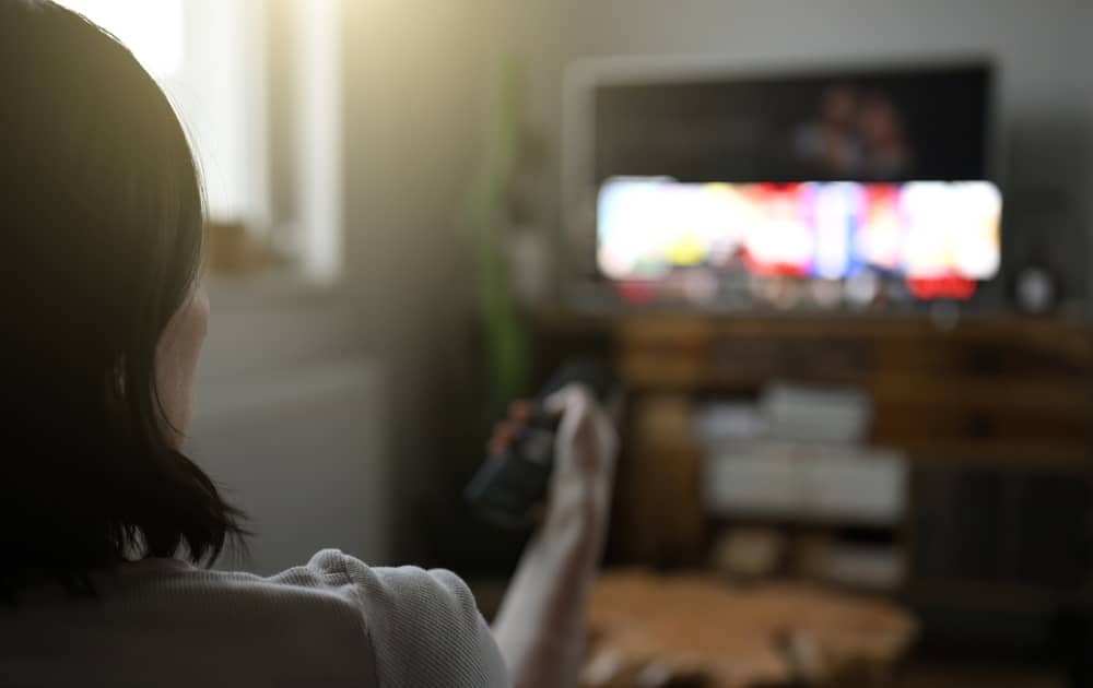 femme allumant sa télé pour regarder une émission avec Thomas Sotto