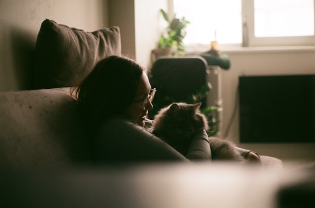 femme et son chat regardant TLC sur un canapé