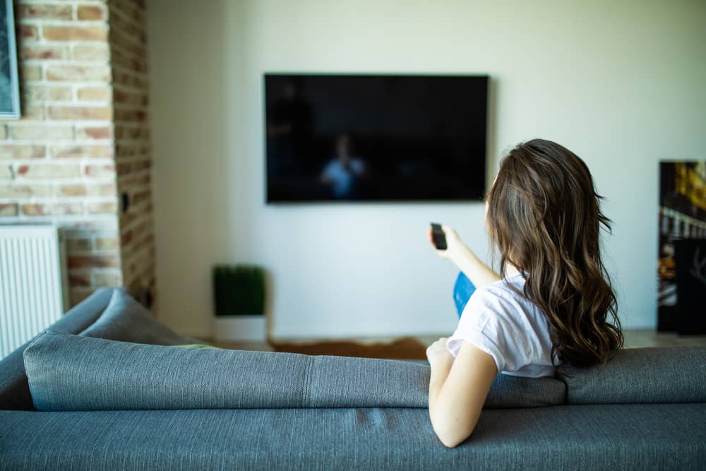 femme allumant sa télé pour regarder TMC