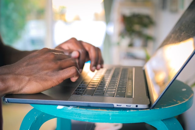 mains d'une personne envoyant un mail à la chaîne Wéo depuis son ordinateur