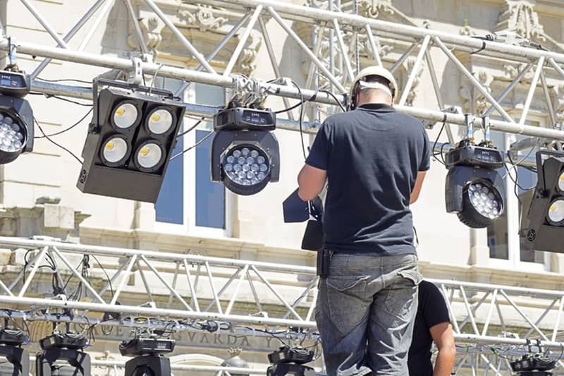 technicien bénéficiant du statut d'intermittent du spectacle en train de monter une scène