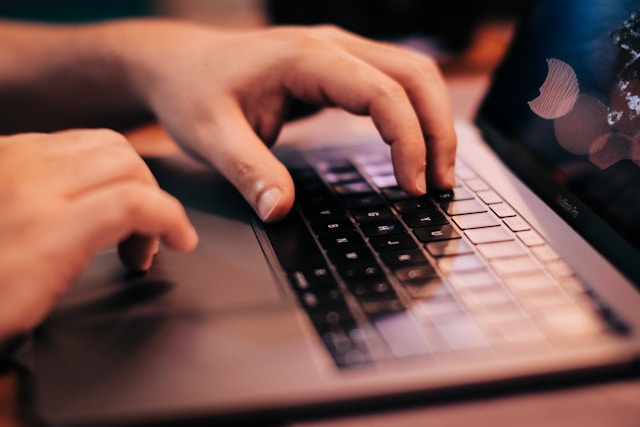 mains d'une personne envoyant un mail pour demander une interview à un journal radio
