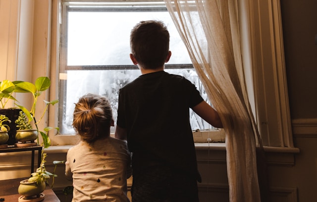 2 enfants regardent par la fenêtre d'une maison visité pendant "Recherche appartement ou maison"