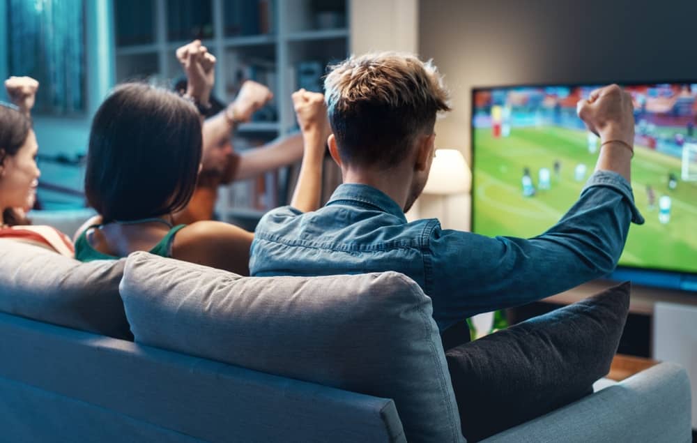 groupe d'amis regardant un match à la télévision grâce à un VPN