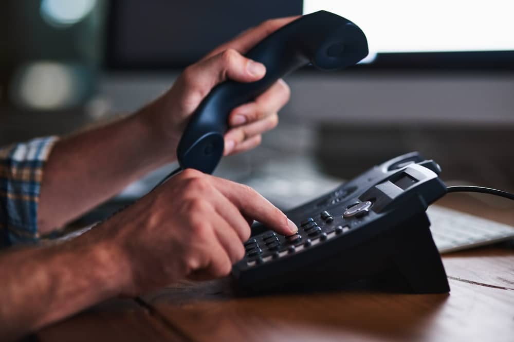 mains d'un homme utilisant un téléphone pour appeler un journaliste