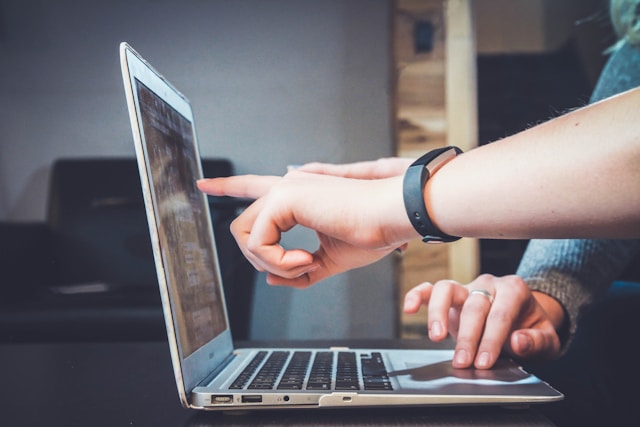 deux personnes montrant le site de la SACEM un écran d'ordinateur portable 