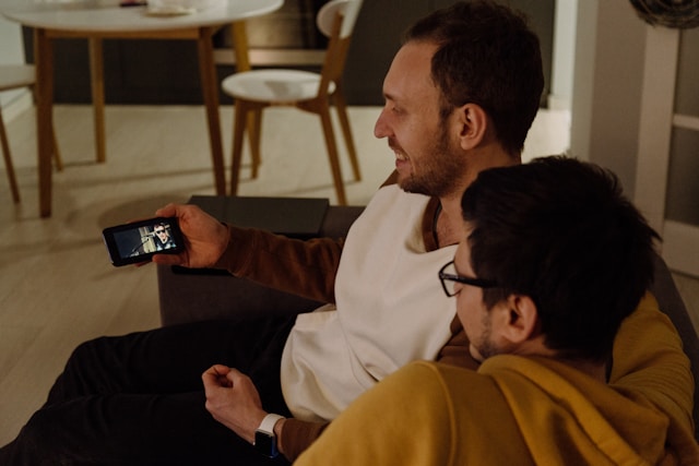 deux hommes regardent un clip sur YouTube Music depuis un smartphone
